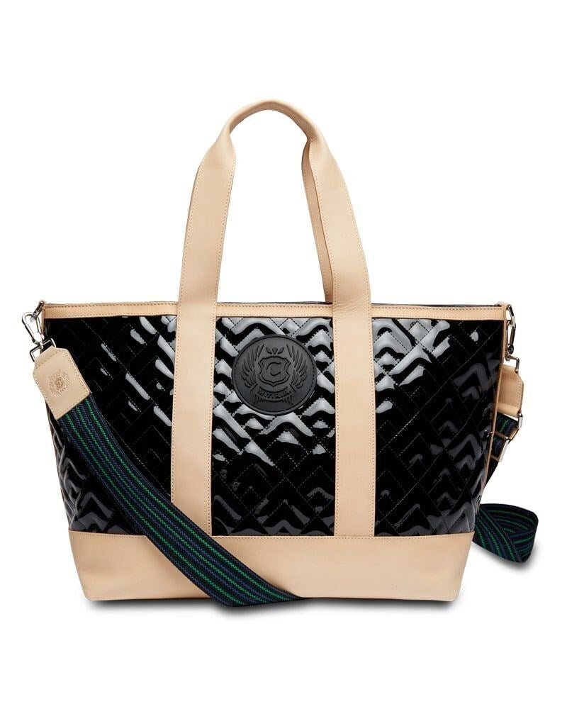 Black patent quilted tote bag with tan leather trim, crest logo, and striped crossbody strap.
