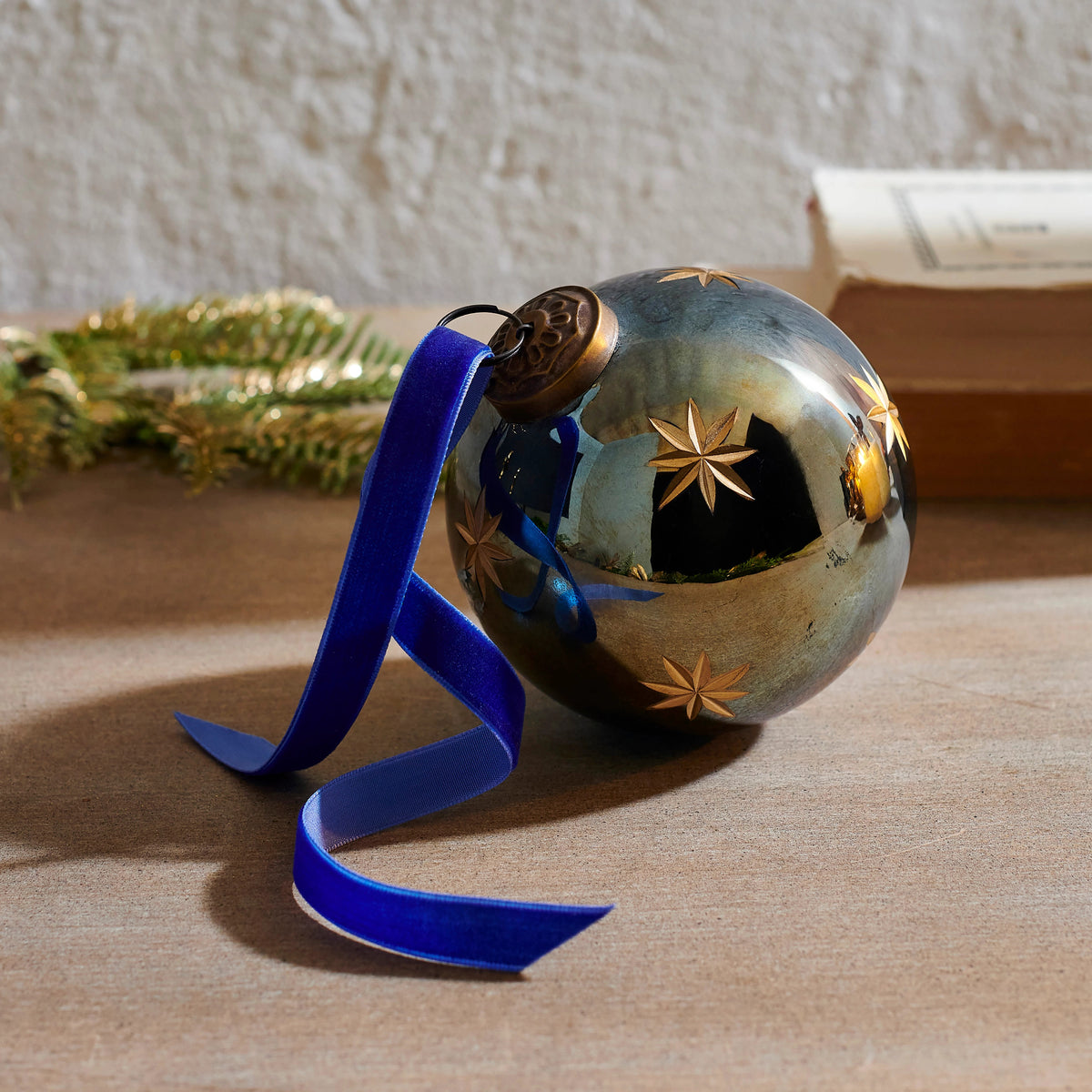 4-inch etched blue glass star ornament with a velvet ribbon on a wooden surface.