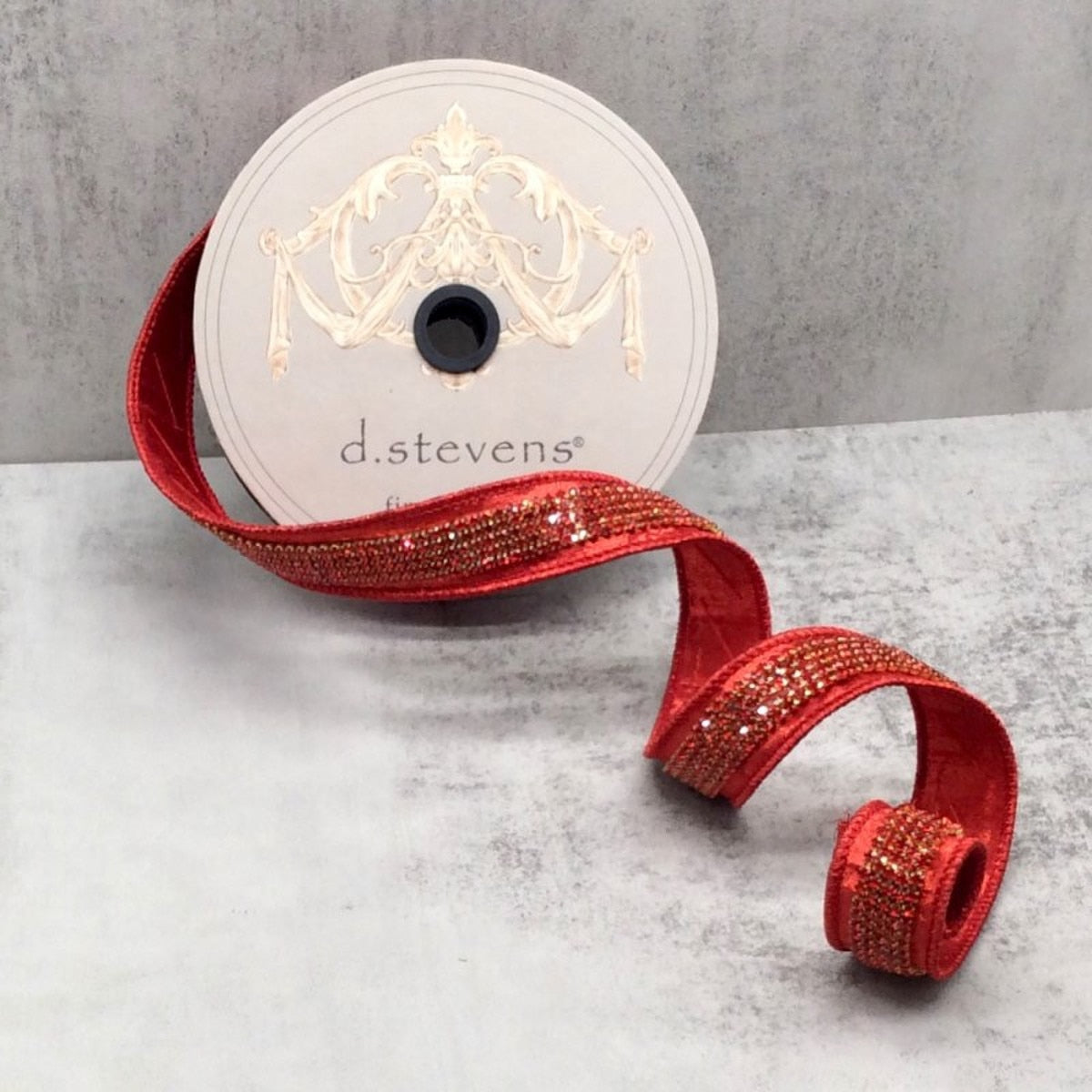 Red metallic dupion ribbon with a sparkling jewel-encrusted center on a d.stevens spool.