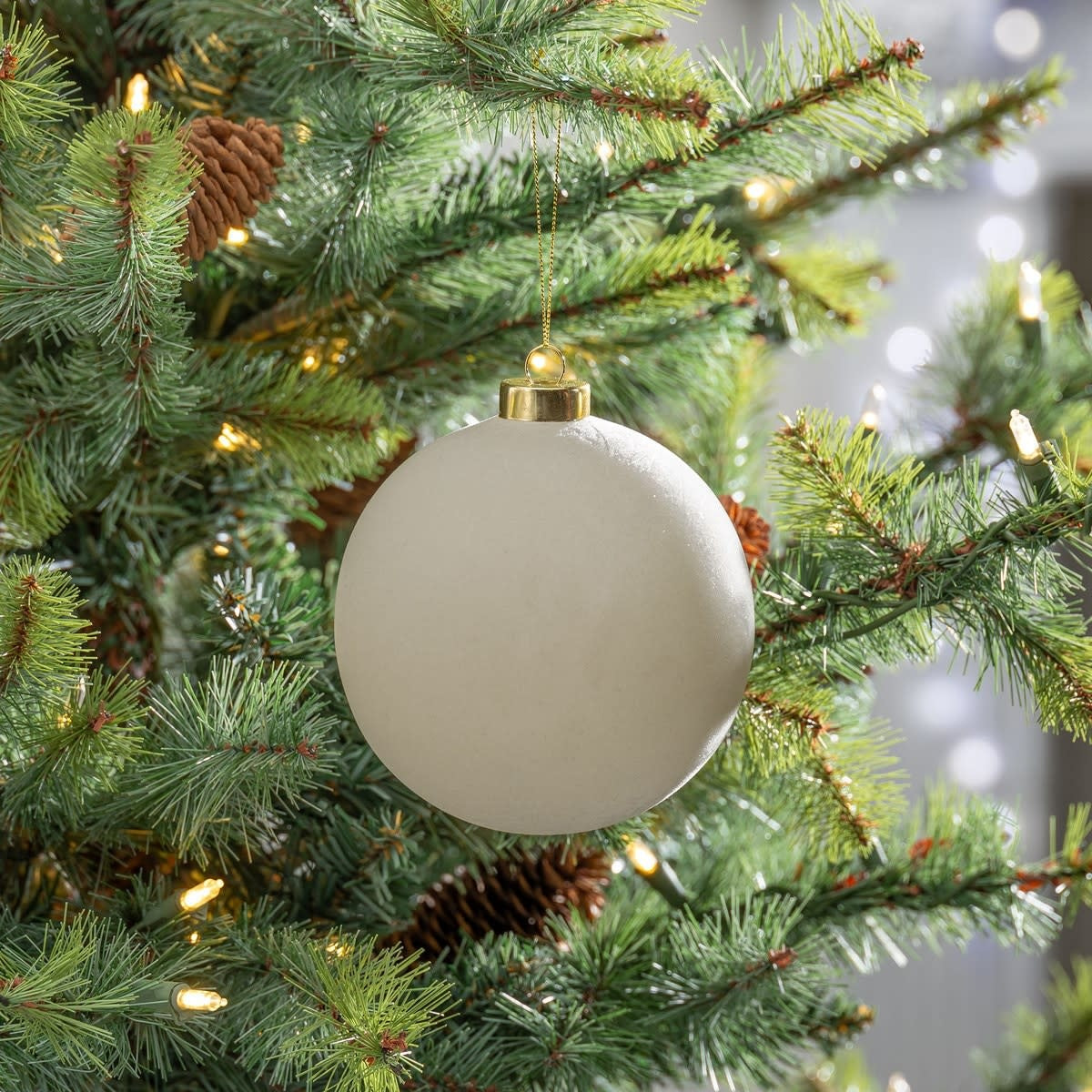 Taupe flocked glass ornament with a round shape.