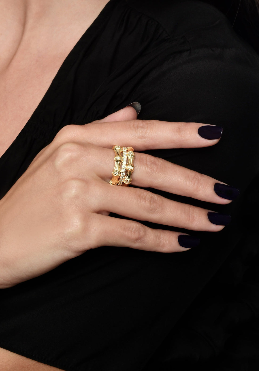 A person wearing a wide 18K gold-plated Bamboo Stack Ring with crystal pavé on their ring finger.