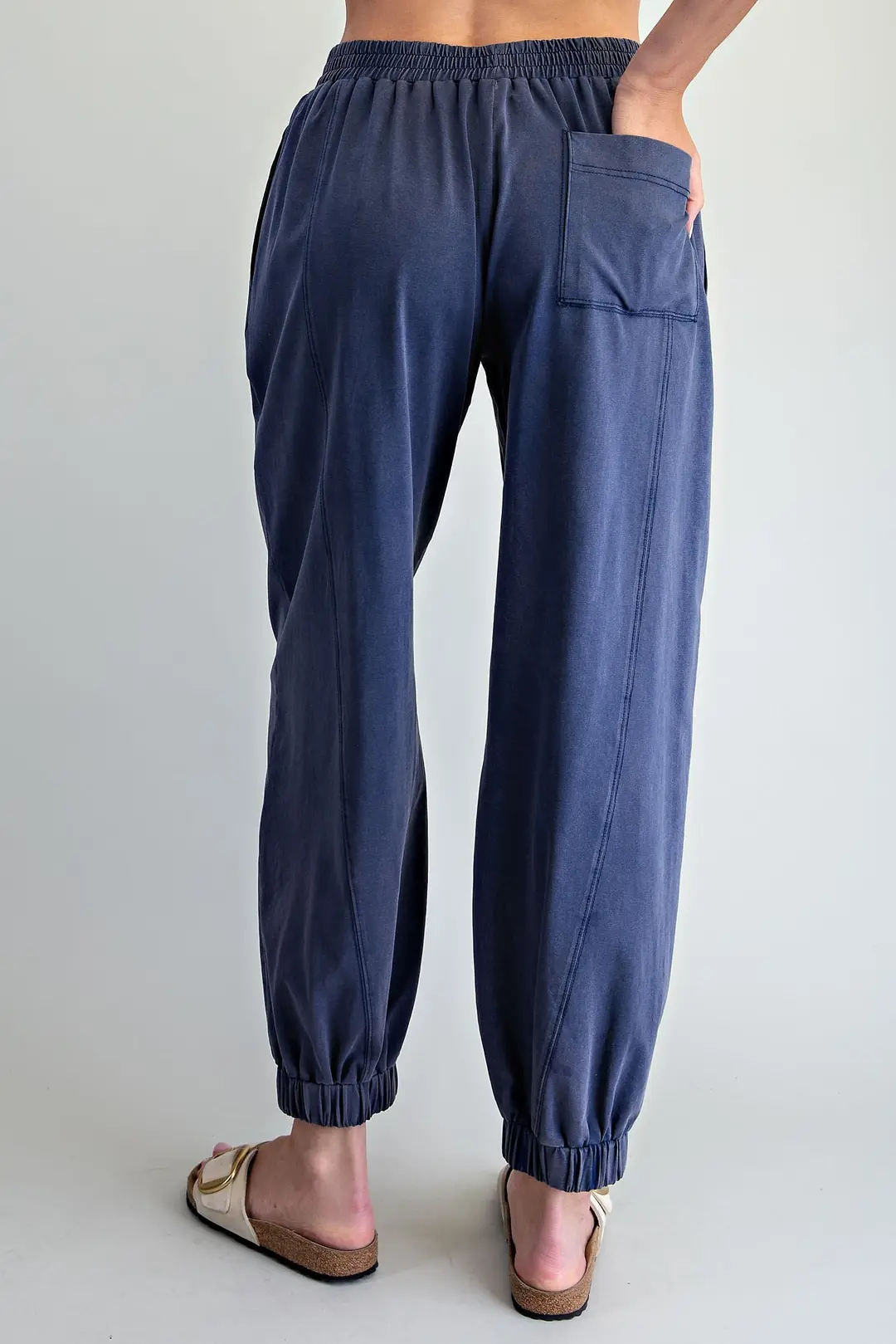 Back view of navy blue Odette joggers with elastic waist, back patch pocket, and vertical seams.
