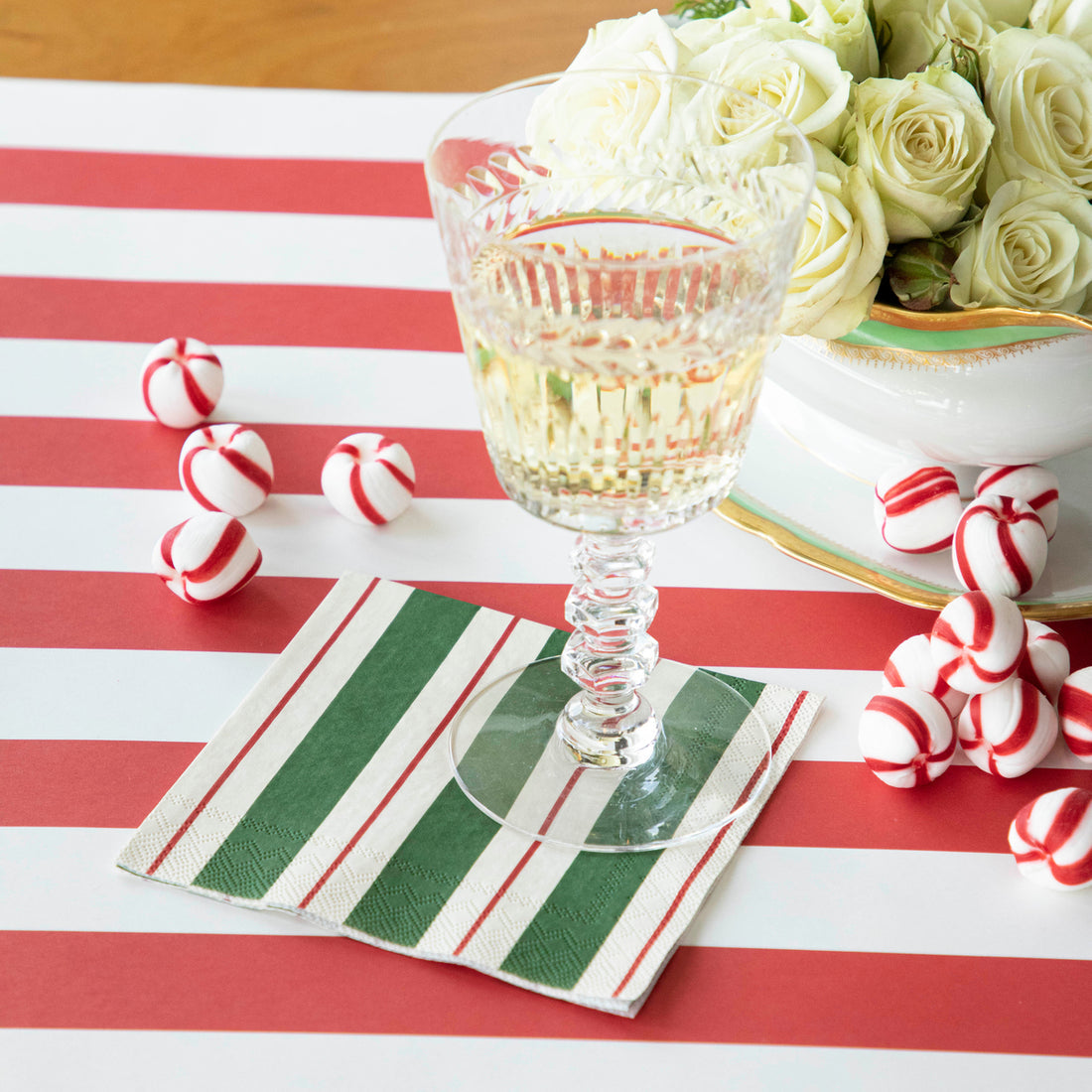 Green and red striped cocktail napkin folded square with white background