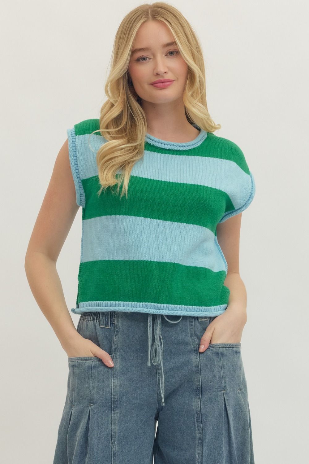 Woman wearing the Kathleen Striped Cap Sleeve Top in green and light blue with denim pants.