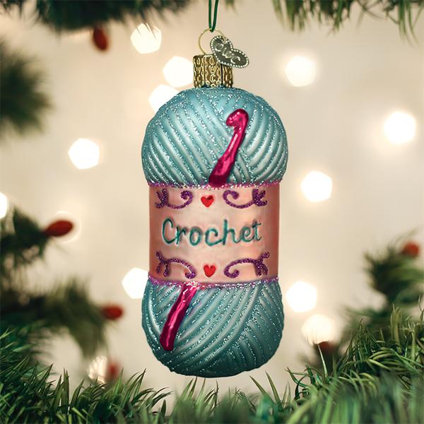 Glass skein of blue yarn Christmas ornament with a pink crochet hook and the word Crochet.