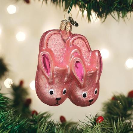Pink glittery bunny slippers glass Christmas ornament hanging on a tree.