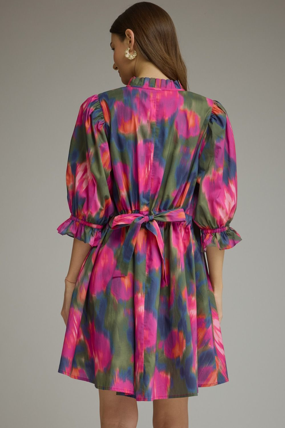 Back view of a woman wearing the Agatha Printed Puff Sleeve Mini Dress with a self-tie waist belt.