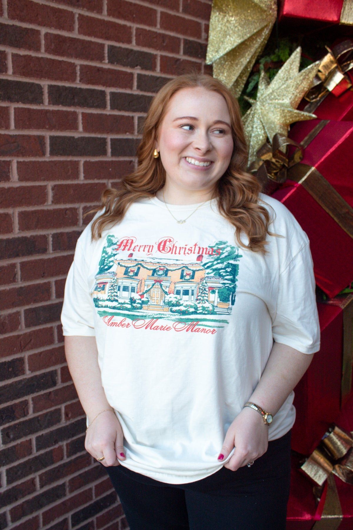 Ivory Christmas t-shirt featuring an illustration of a decorated manor with the text Merry Christmas Amber Marie Manor.
