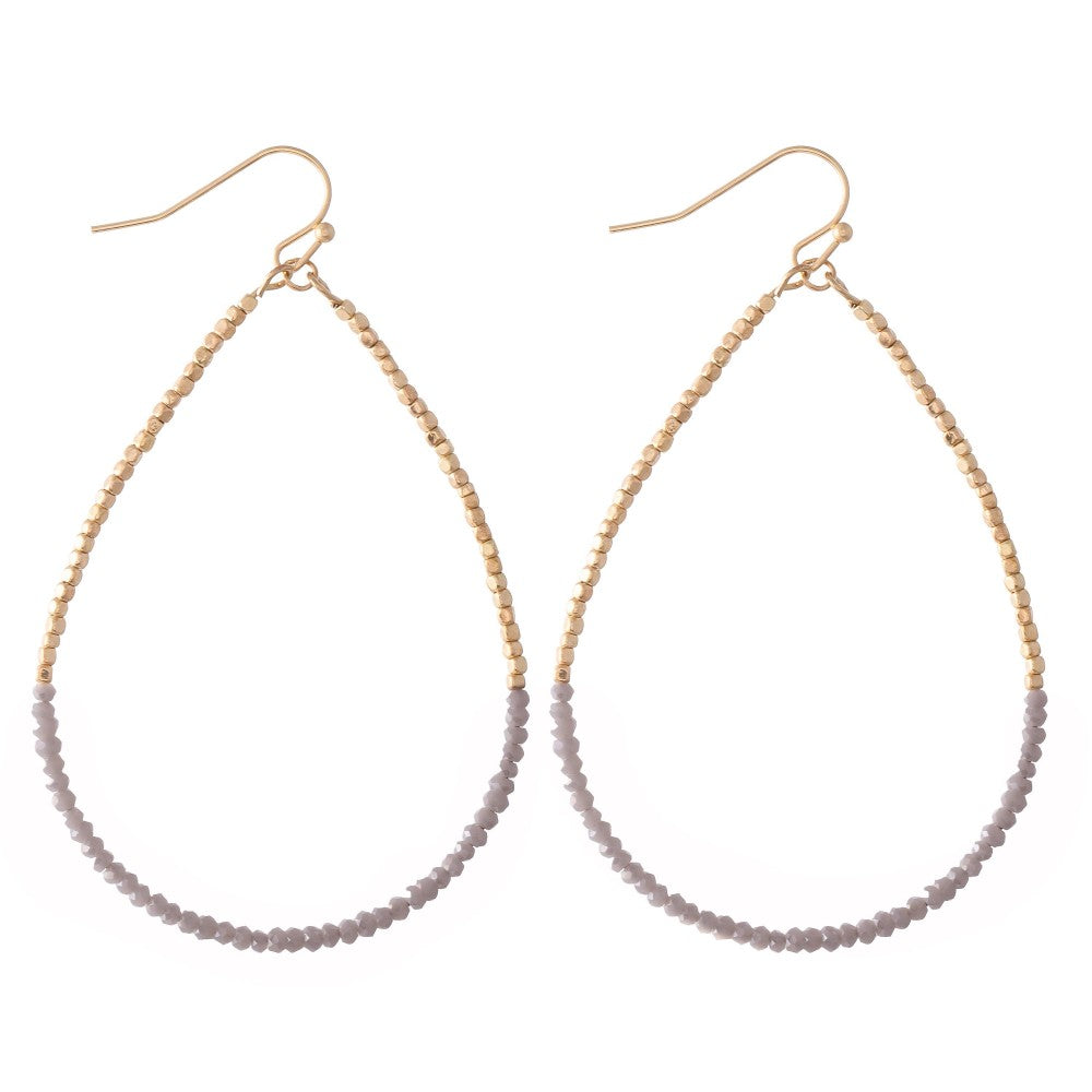 Long dainty beaded teardrop earrings with gold and grey beads on gold-tone hooks.