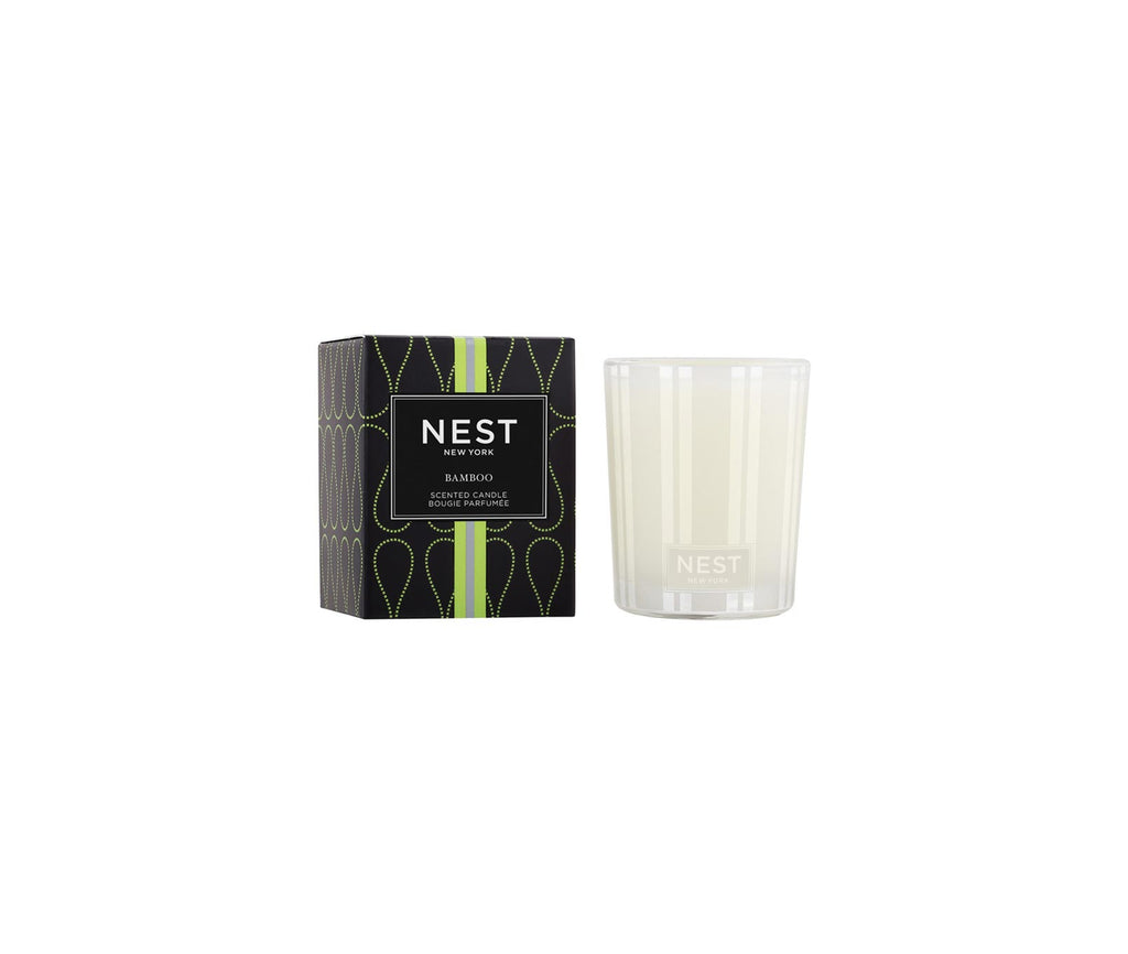 Nest Bamboo votive candle in a frosted glass vessel next to its black and green patterned box.