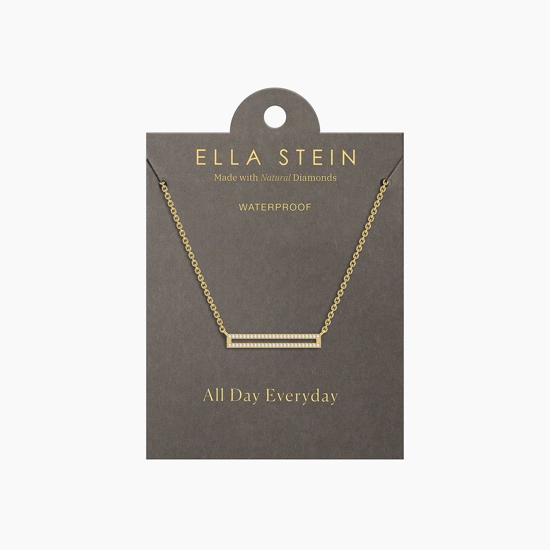 Gold bar pendant necklace with diamonds on a grey display card labeled Ella Stein.