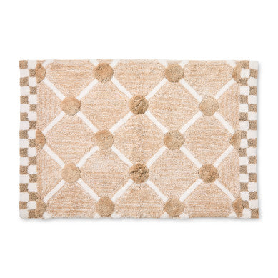 Handmade cotton bath rug with a lattice and dot pattern in neutral tones.