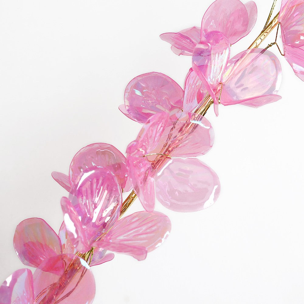 Artificial floral stem with pink roses in a white vase