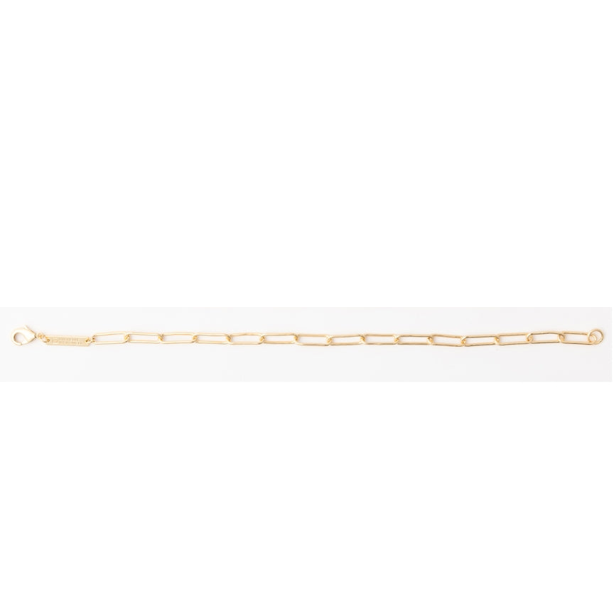 Gold paperclip chain bracelet with a small tag and clasp.