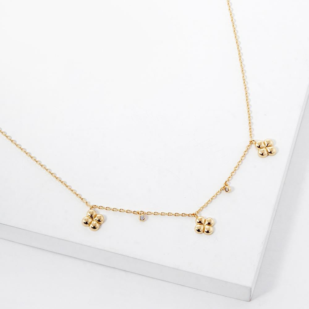 Gold-dipped chain necklace featuring three four-leaf clover charms and two small crystal accents.