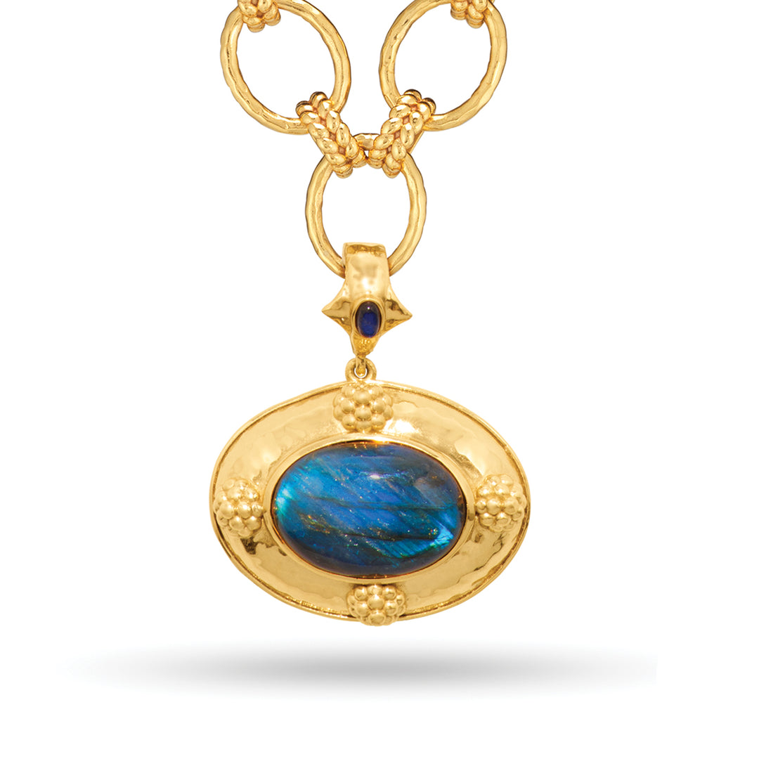 Gold Cleopatra pendant necklace featuring a large oval blue labradorite stone and textured links.