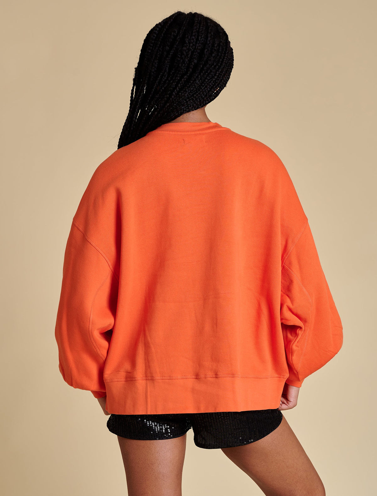 Back view of a black balloon sleeve pullover with a relaxed fit.