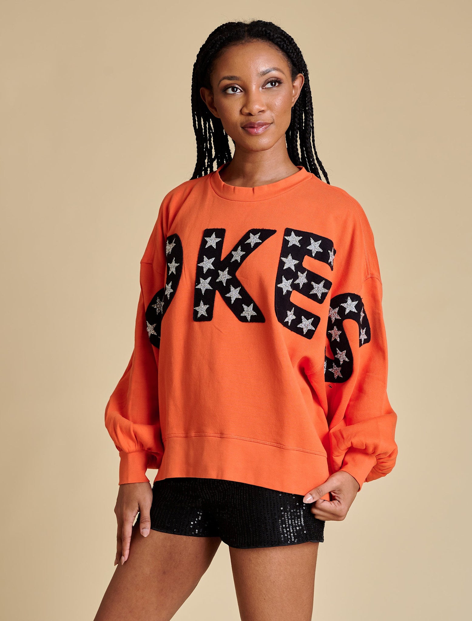 Side view of a beige balloon sleeve pullover with a relaxed fit.