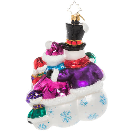Three white snowman figurines with black eyes and carrot noses huddled together in a group hug.