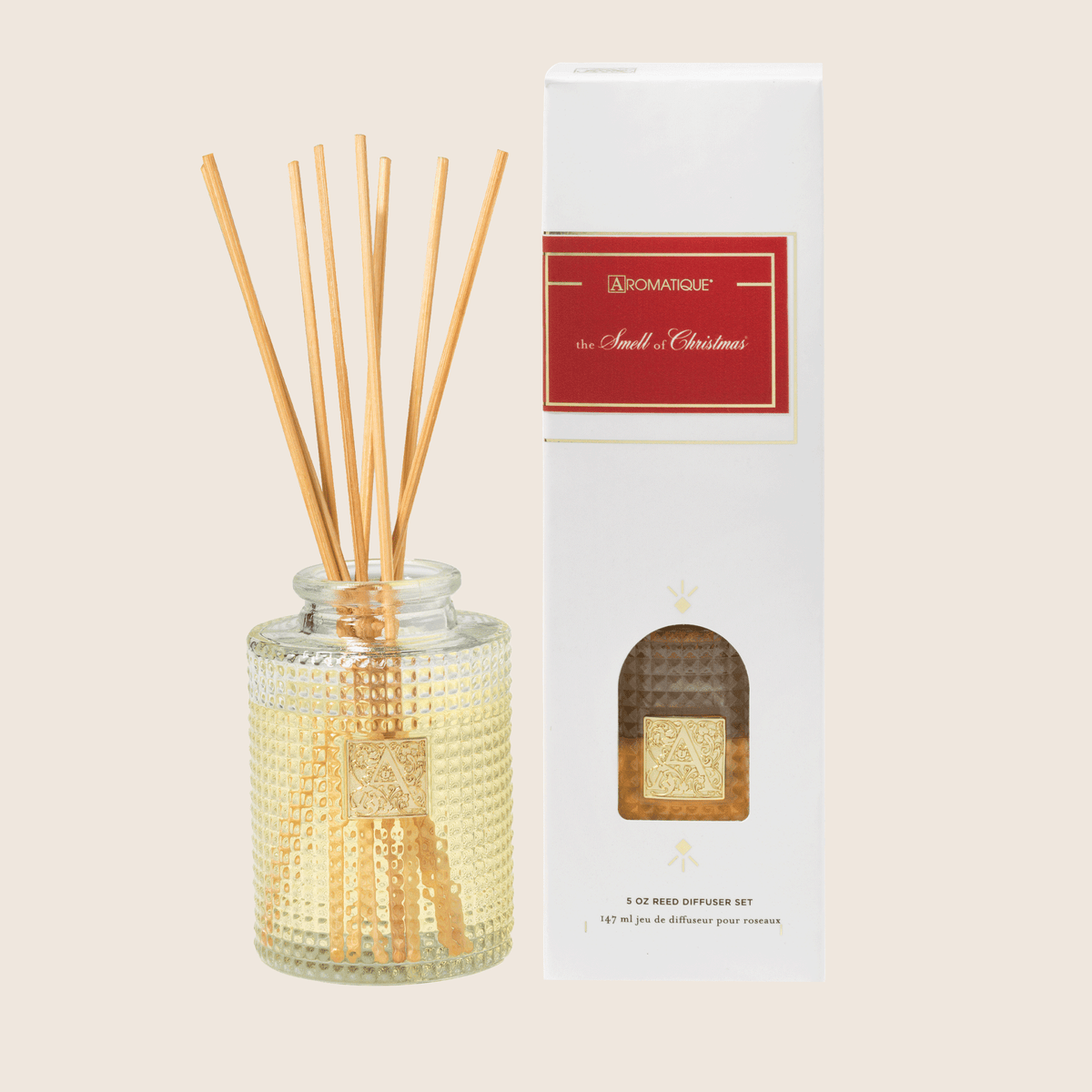Textured glass bottle containing The Smell of Christmas reed diffuser with visible fragrance wicks.