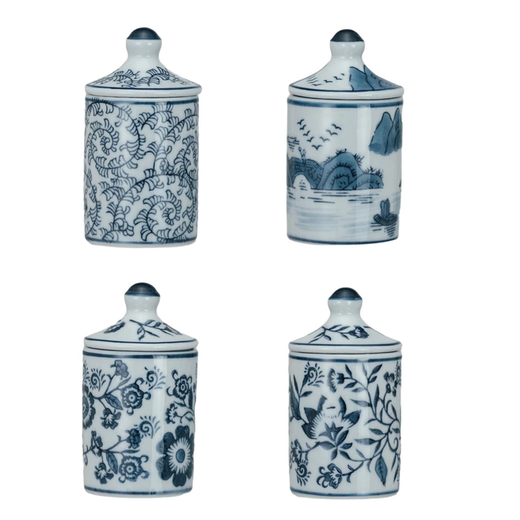 Four hand-painted blue and white stoneware spice jars with various floral and landscape patterns.