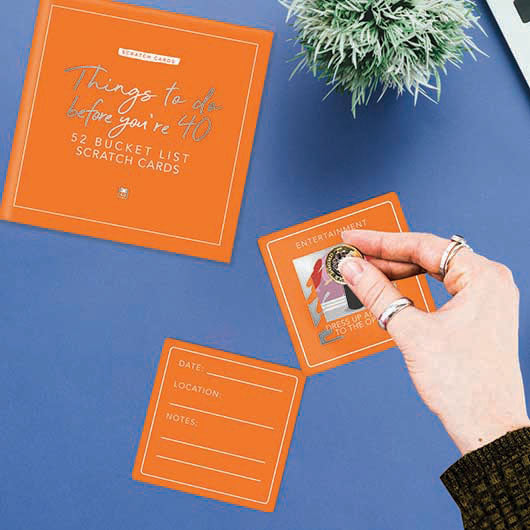 Packaging for Things To Do Before Your 40 Card featuring a white box with colorful activity cards and scratch-off panels.