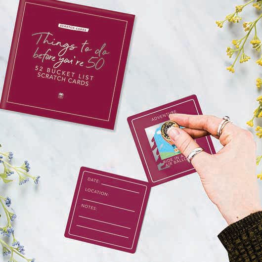 Pack of scratch cards with colorful panels revealing activities to do before turning fifty.