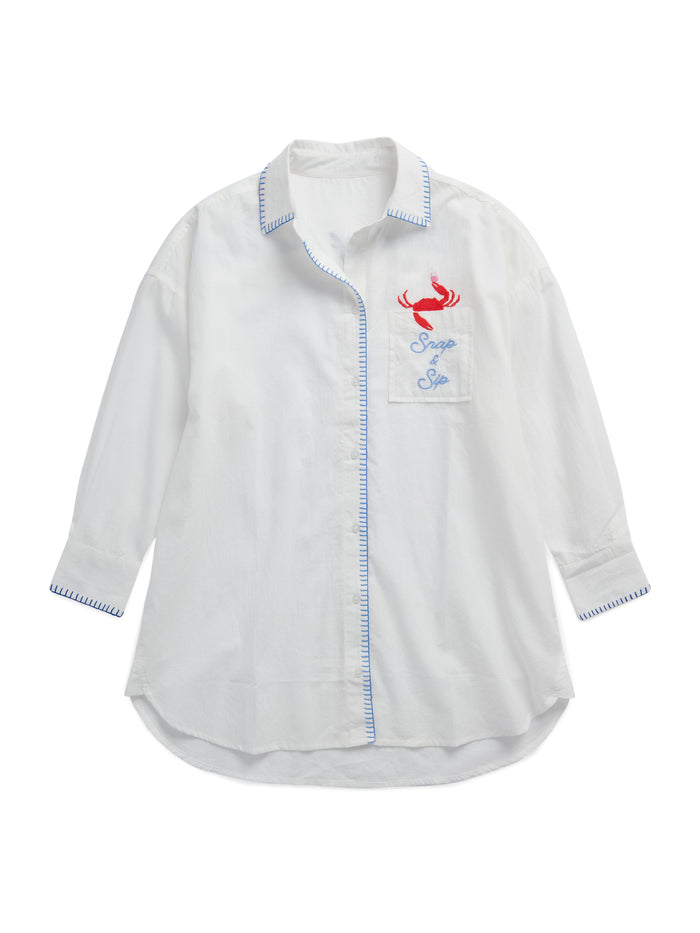 Relaxed-fit cotton button-down cover-up shirt with rolled cuffs featuring red crab embroidery and ocean-blue stitching details.