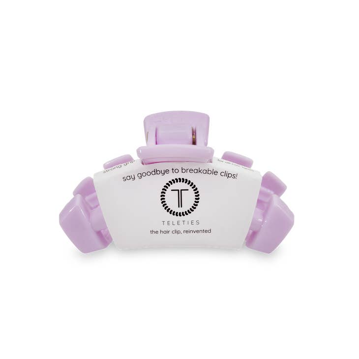 Tiny light purple Teleties hair clip on its white cardboard packaging.