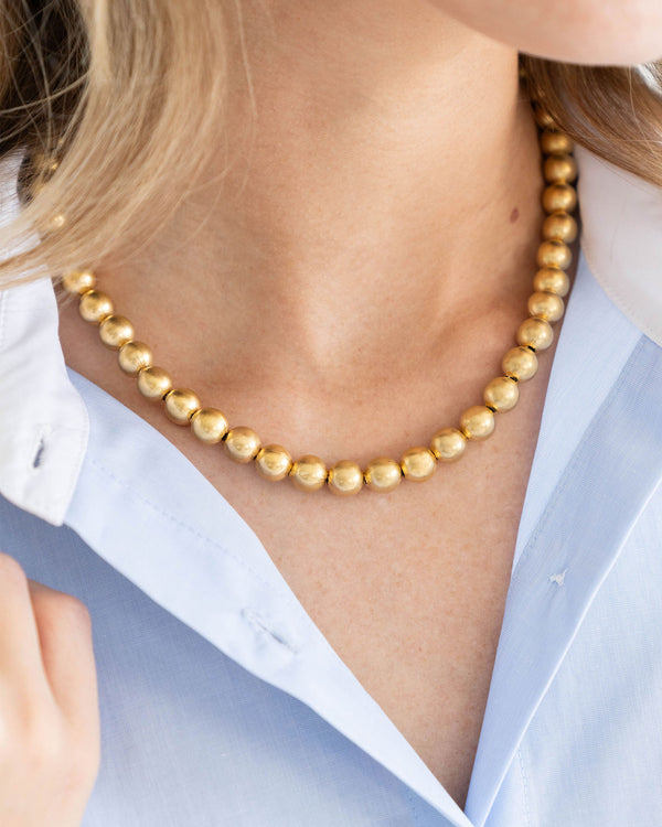 Mini Margaret necklace featuring a triple-plated 24K gold chain with an 18mm oval bead pendant.
