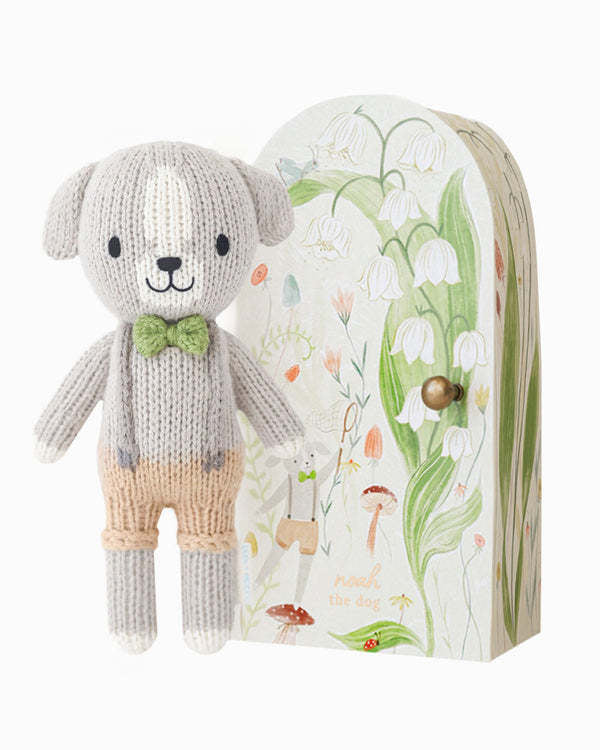 Hand-knit Tiny Noah dog doll in natural cotton yarn with soft facial features.