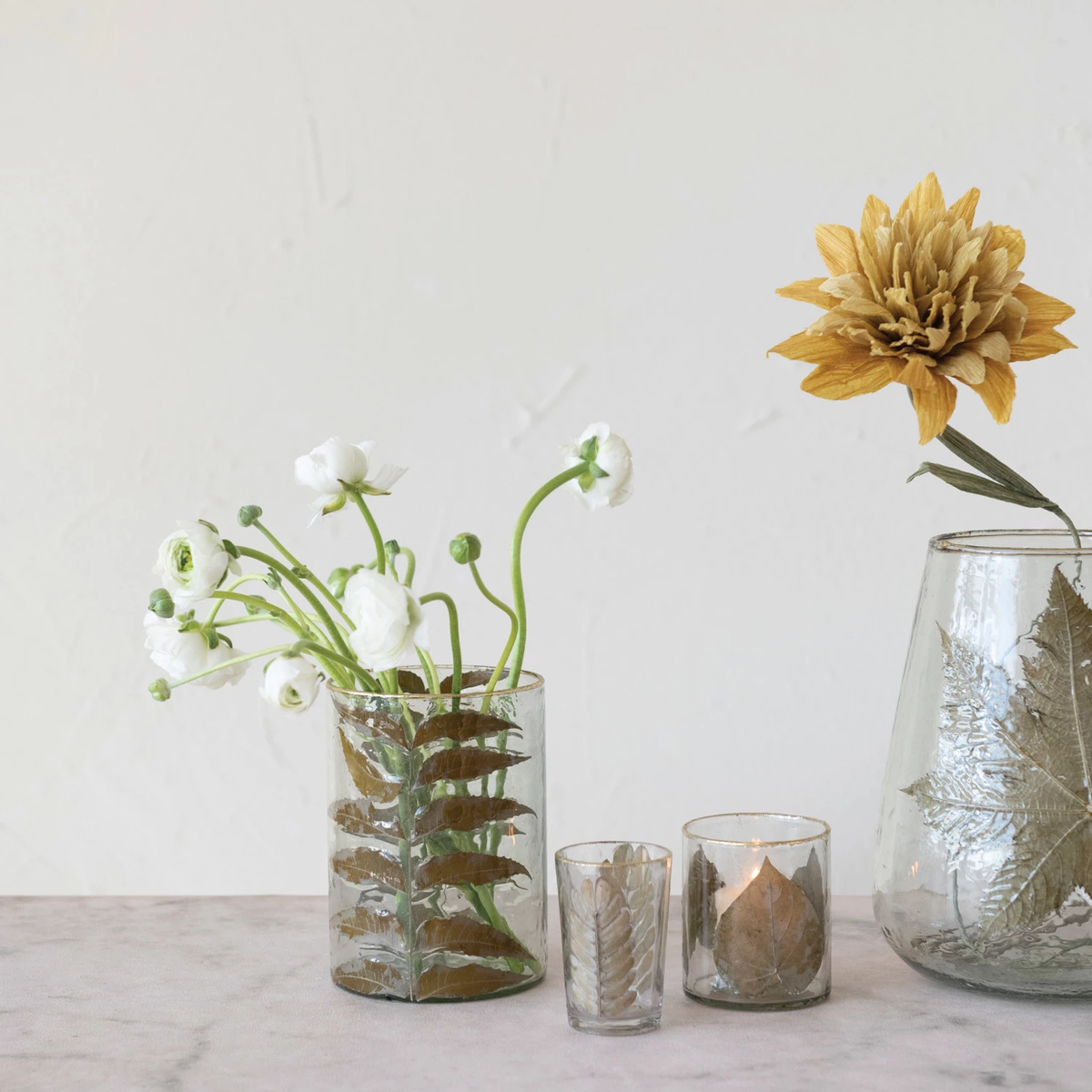 Hand-blown glass votive holder with embedded tamarind leaves and gold foil edge