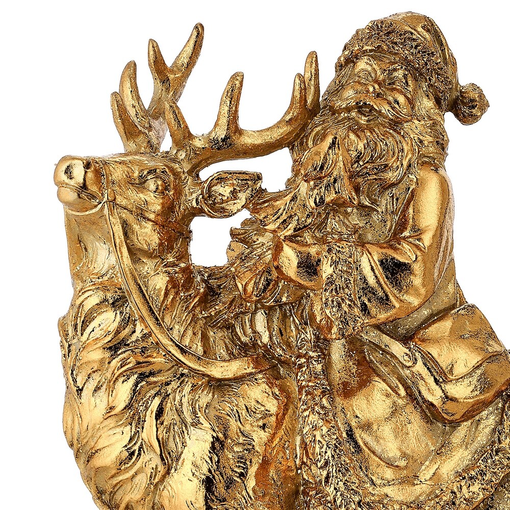 Gold resin table piece featuring a detailed Santa Claus riding a majestic reindeer.