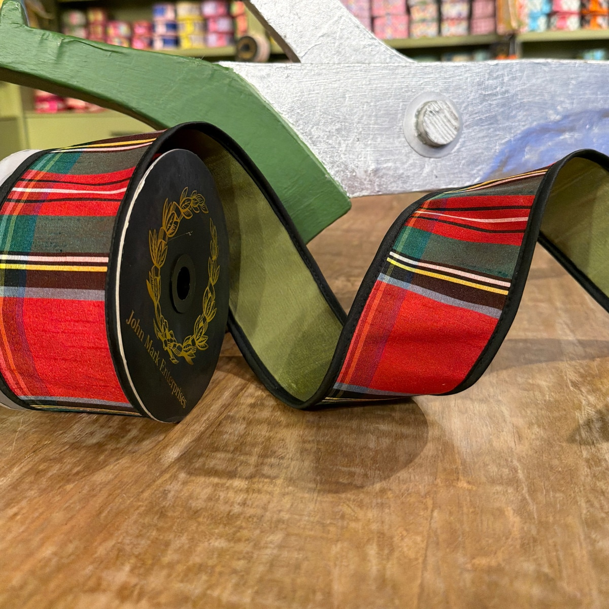 2.5 inch Royal Stewart plaid fused dupion ribbon in olive green on a black spool.