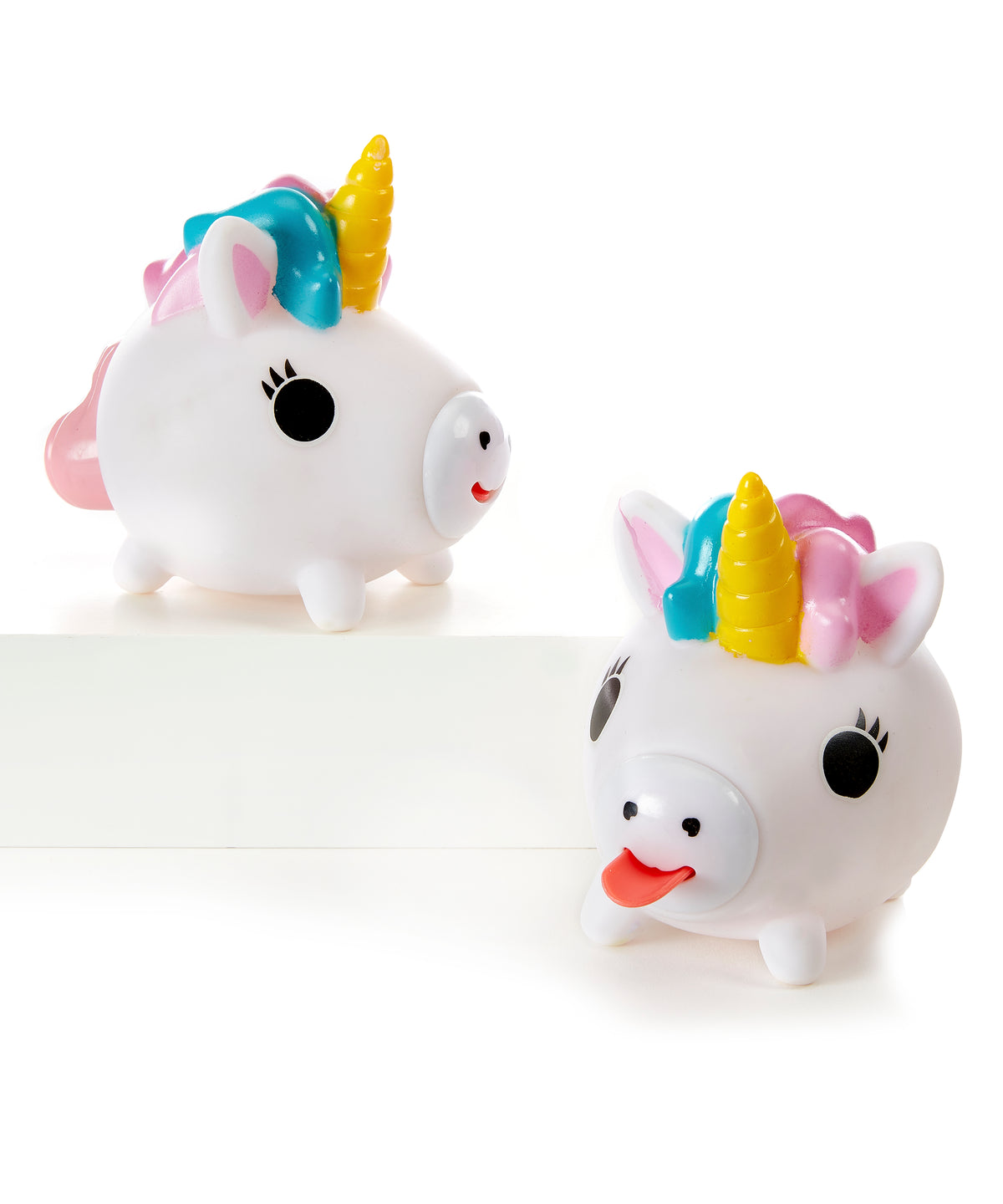 Two white round unicorn toys with colorful manes and horns, one with its red tongue sticking out.