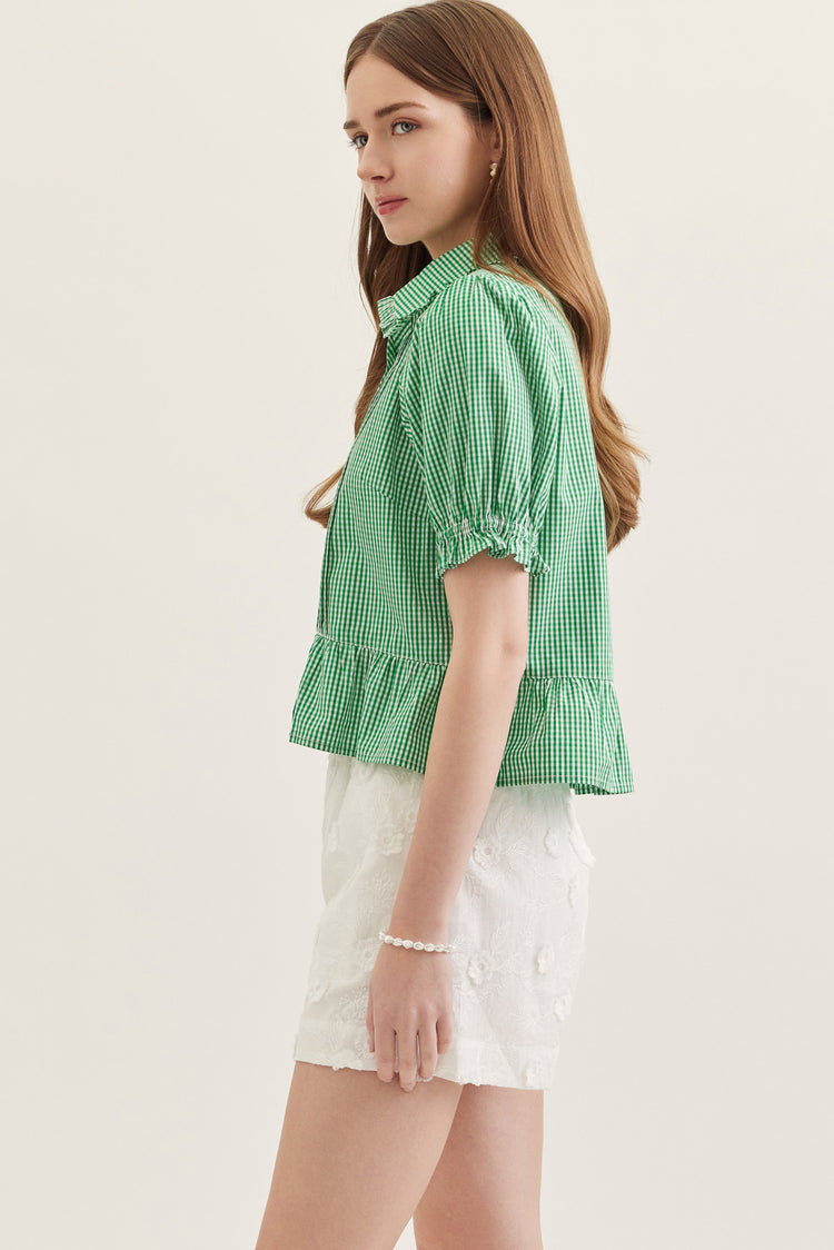 Side view of a woman wearing the green gingham Katie Collared Blouse with ruffled puff sleeves.