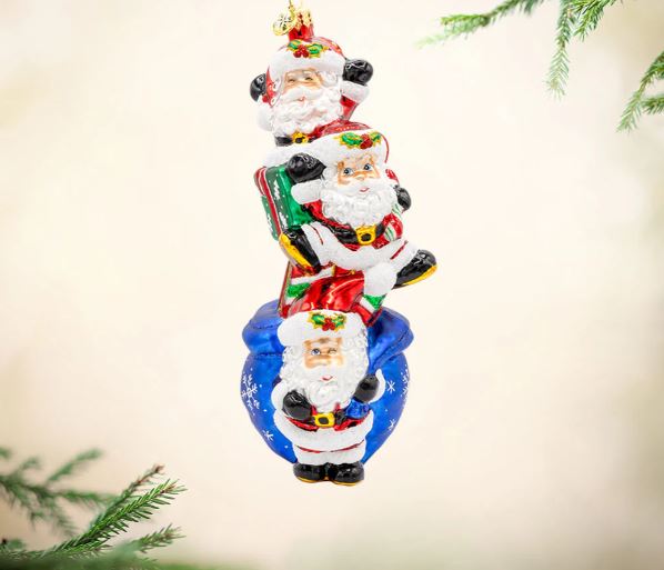 Jolly Santa Trio glass ornament featuring three stacked Santas on a blue sack with snowflake details.