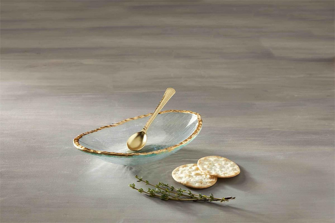 Gold Edge Dip Bowl Set featuring a glass dish with gold rim, gold spoon, crackers, and herbs.