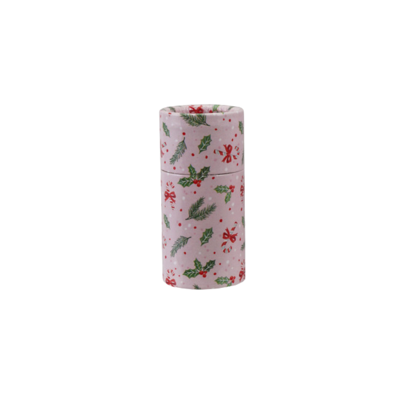 Small pink tube matchbox with a festive holiday pattern of holly, pine branches, and candy canes.