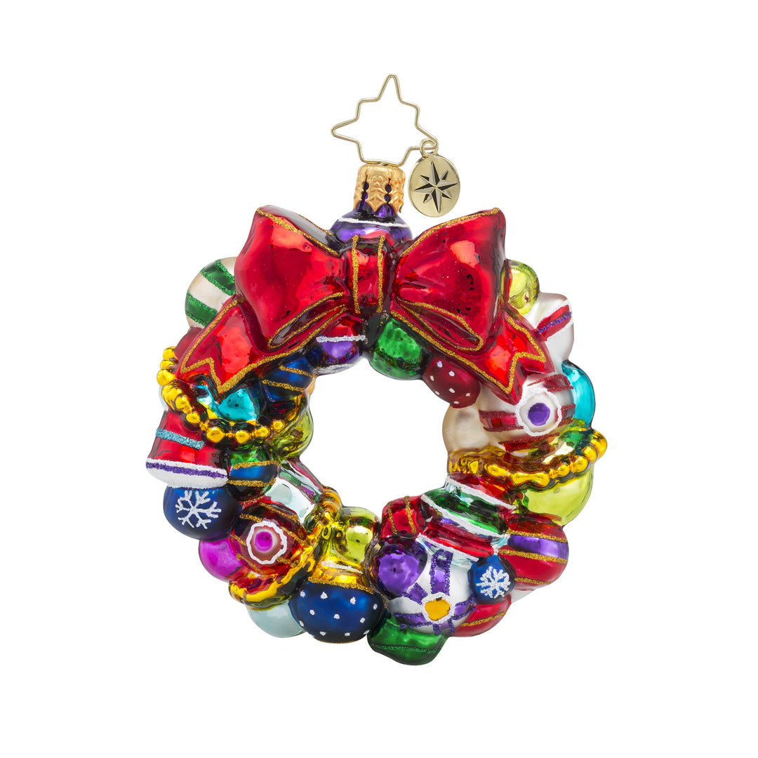 Joyful Wreath Little Gem glass ornament featuring a red bow and colorful miniature baubles.