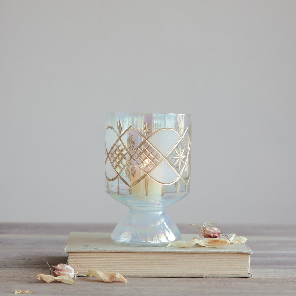 Hand-blown iridescent glass footed votive holder with gold etched diamond and star designs.
