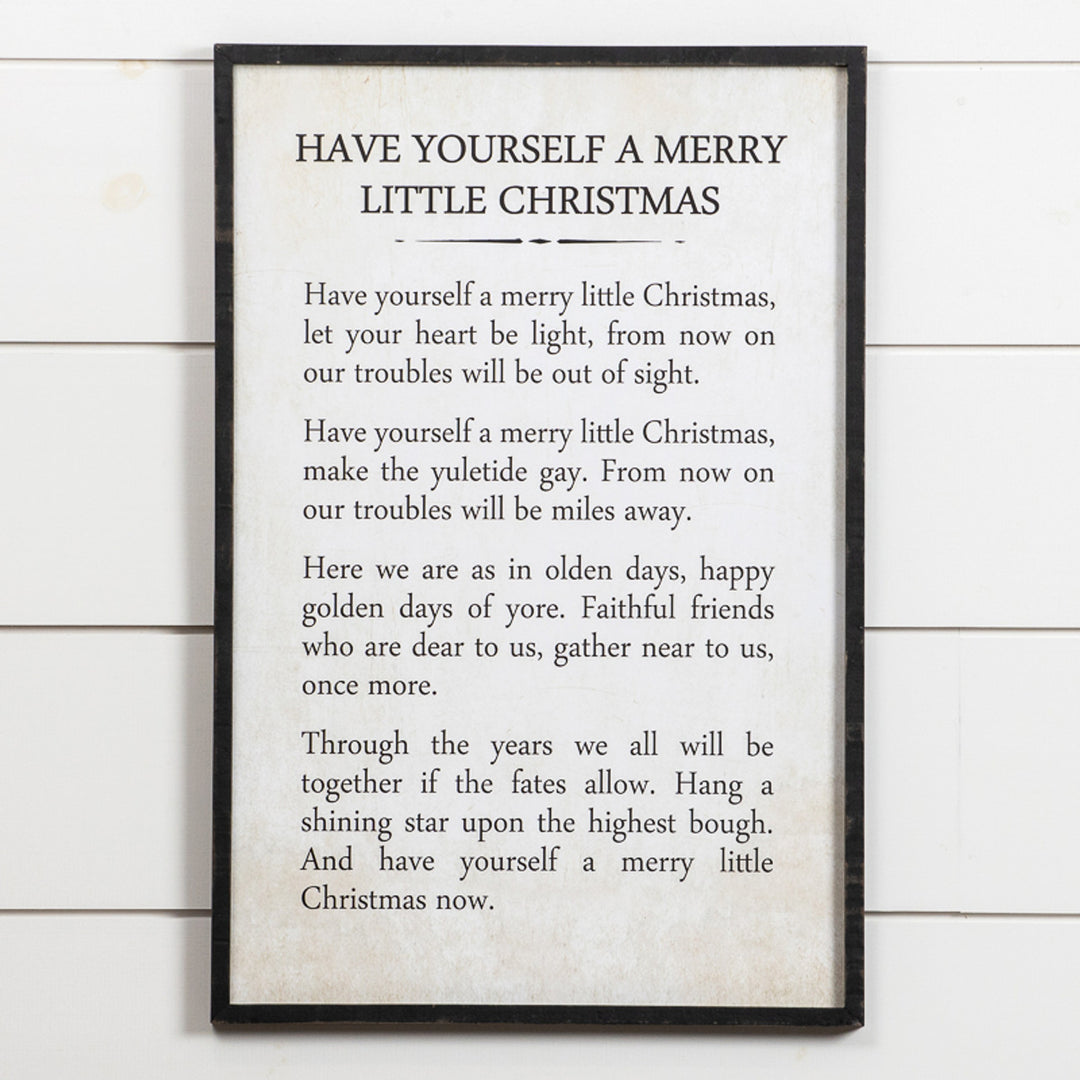 Wooden Merry Little Christmas sign with white lettering on a natural wood background.