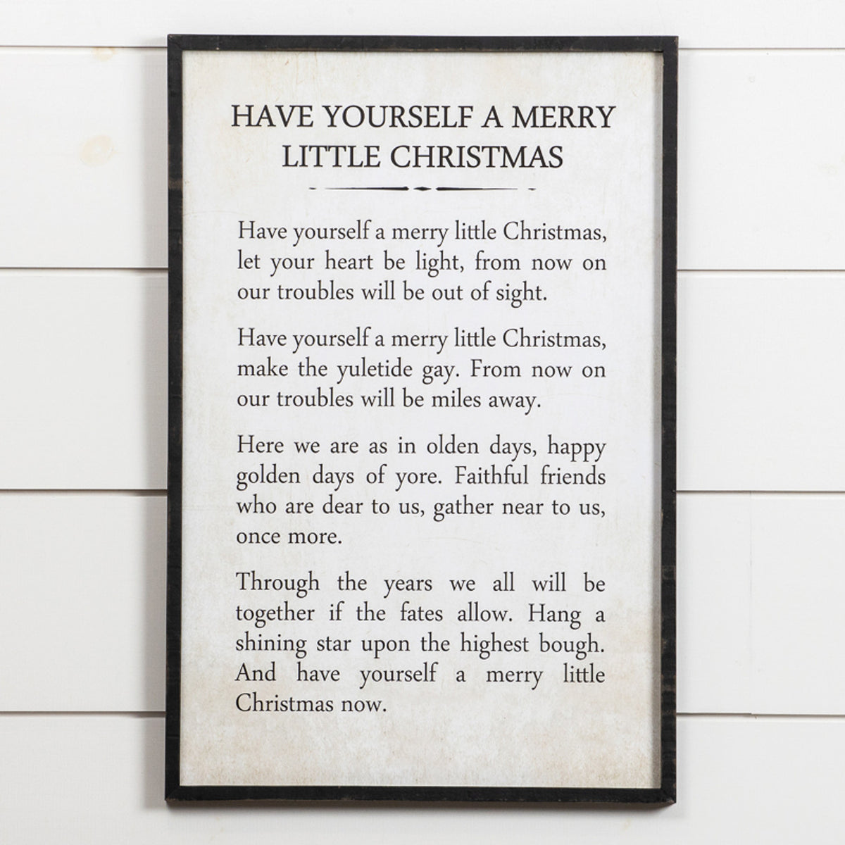 Wooden Merry Little Christmas sign with white lettering on a natural wood background.