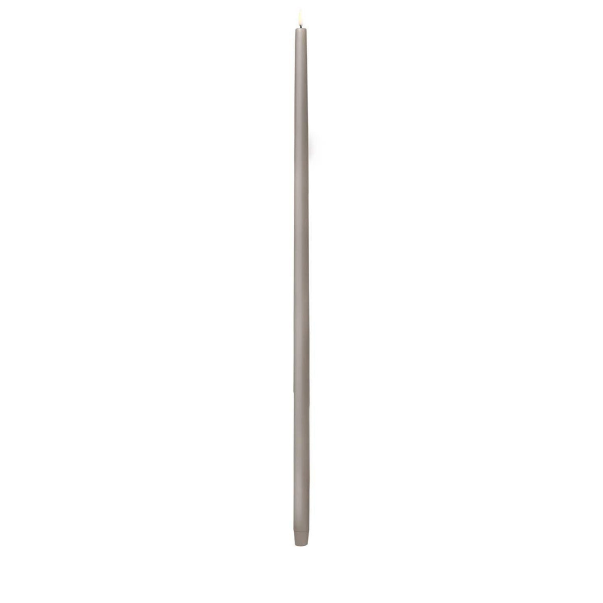 Tall sandstone LED taper candle with smooth finish on a stand