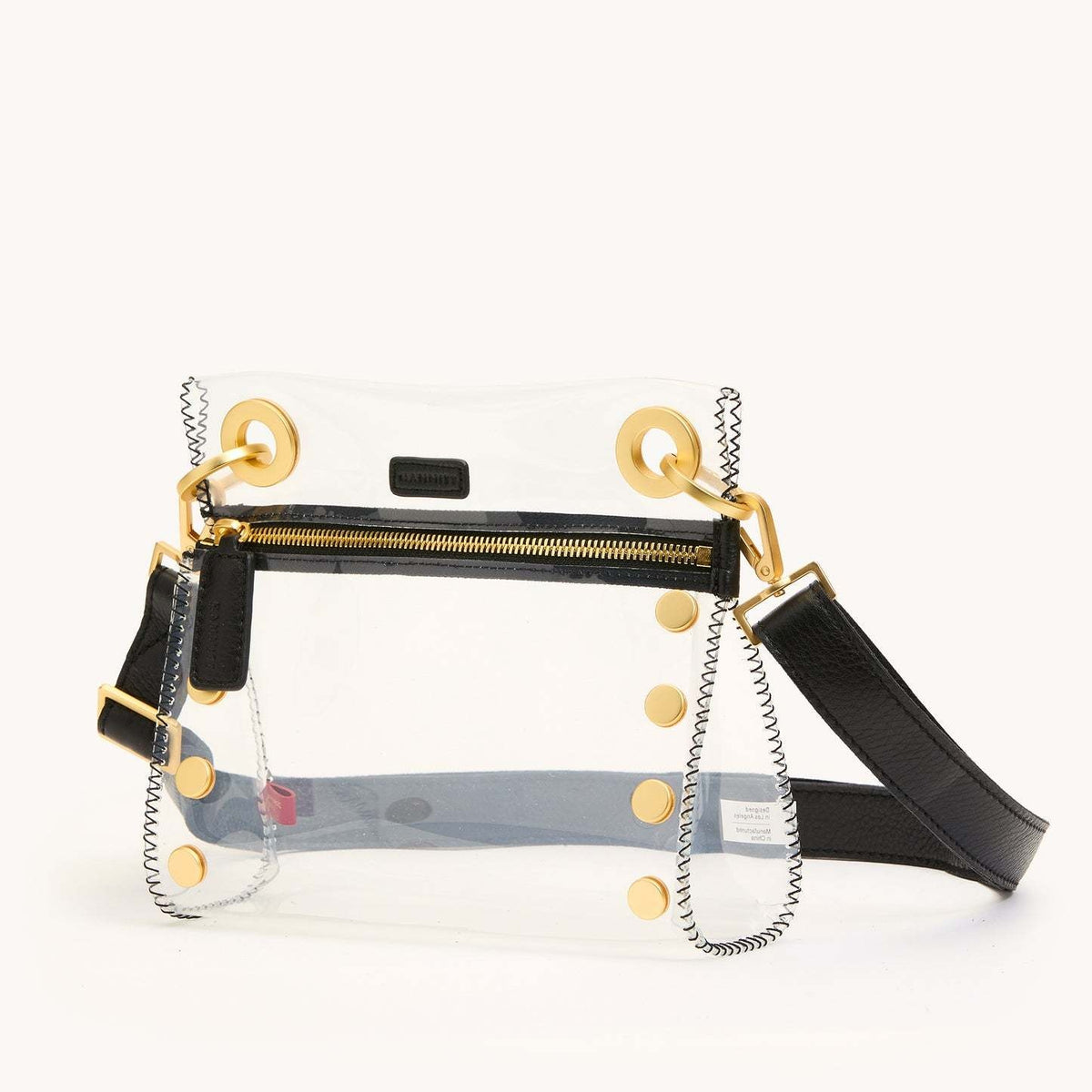 Small Tony clear bag with black brushed gold leather trim and adjustable crossbody strap.