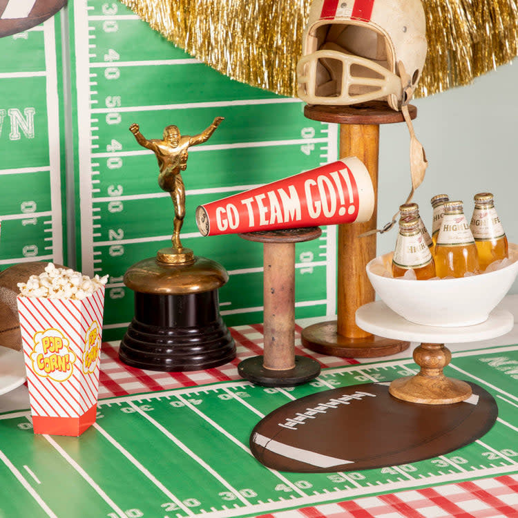 Paper table runner with football touchdown field print in green and gold.