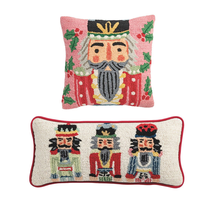 Two hooked wool nutcracker pillows with a festive red hat pattern on a cream background.