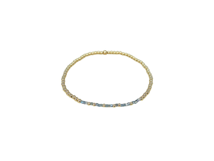 Blessed Bracelet featuring 14K gold-filled beads and blue accent beads on an elastic band.
