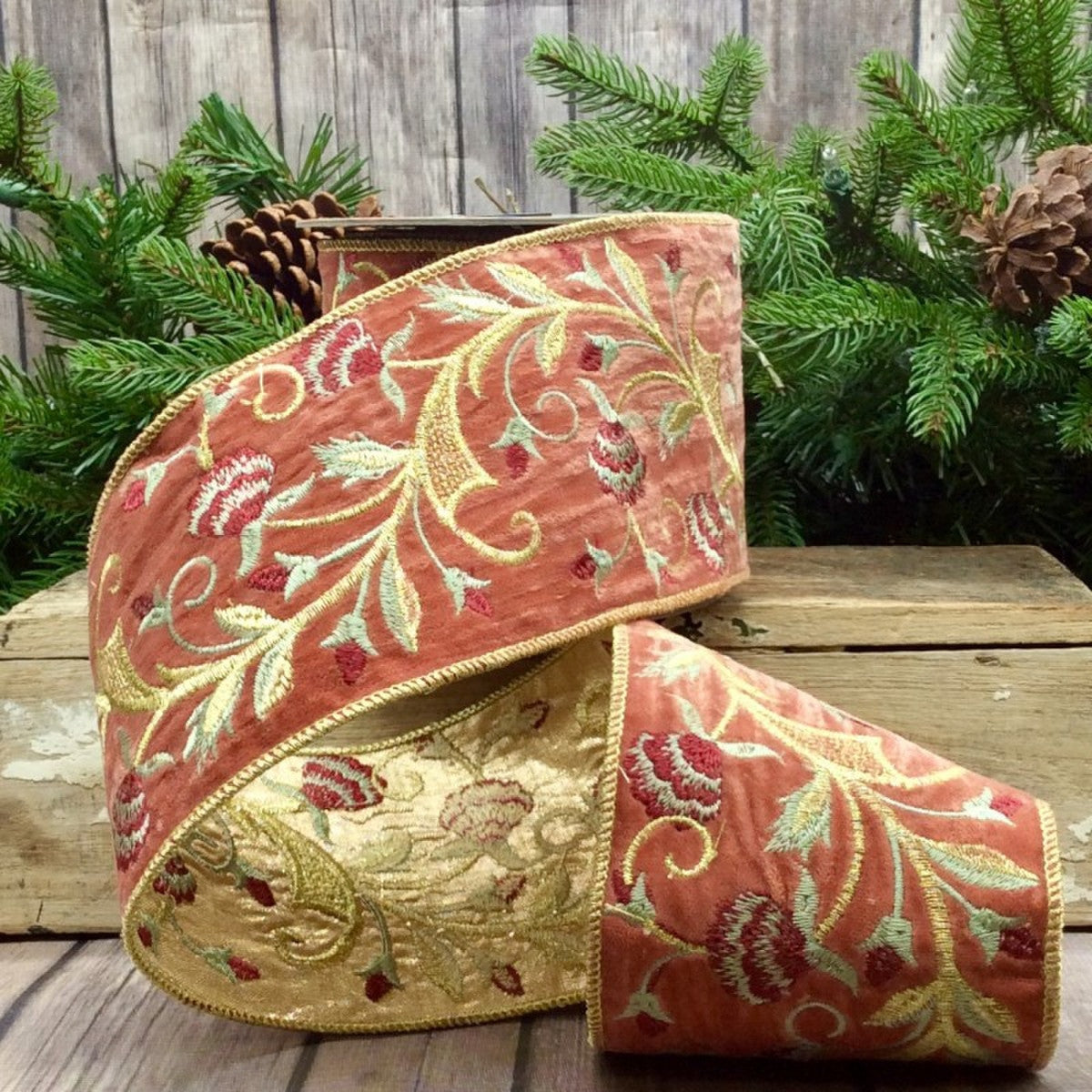 4-inch wide salmon velvet ribbon with burgundy floral embroidery and gold trim on a wooden surface.