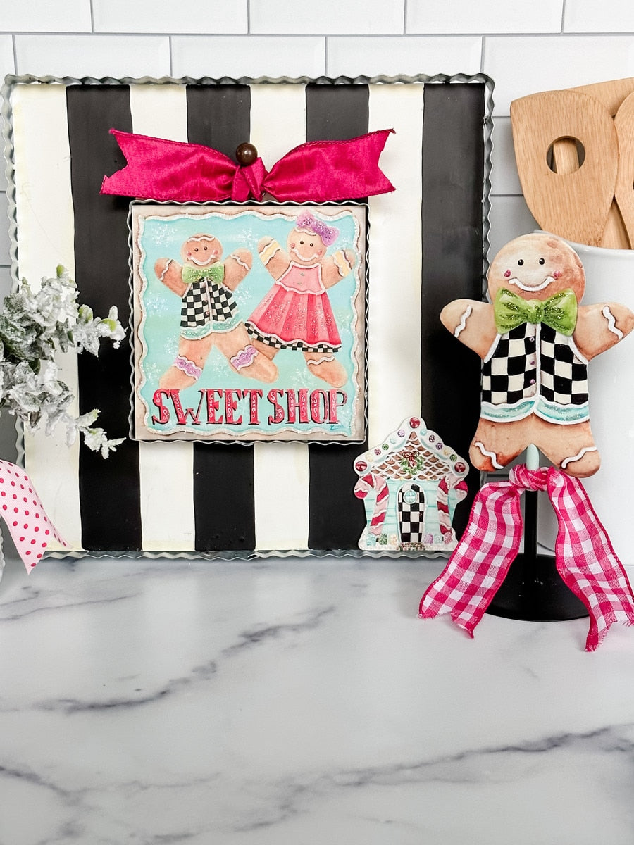 Black and white striped mini gallery display board with a scalloped edge and pink bow accent.